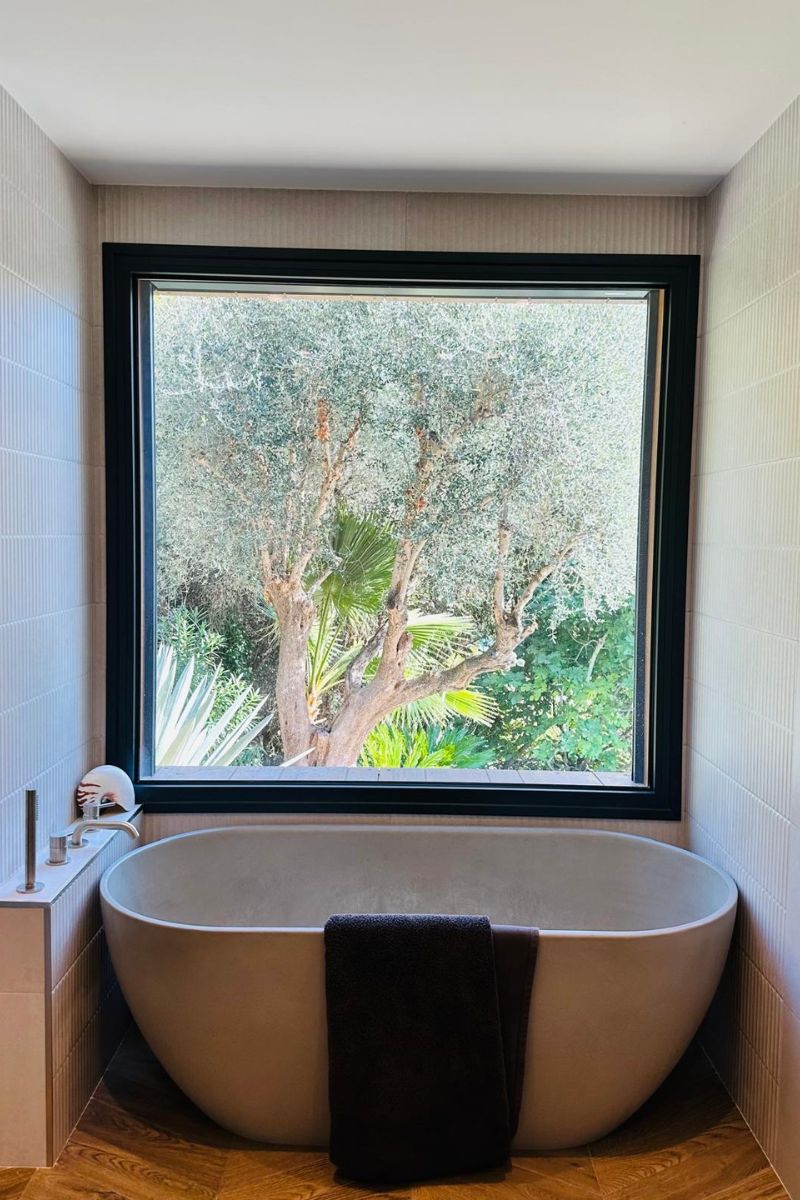 baignoire salle de bain avec une baignoire ovale et vue sur la forêt
